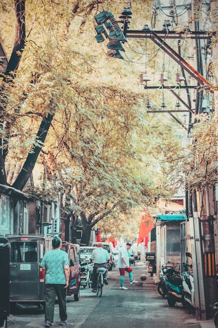 Explore a bustling alleyway in Beijing with people, motorcycles, and vibrant urban life.