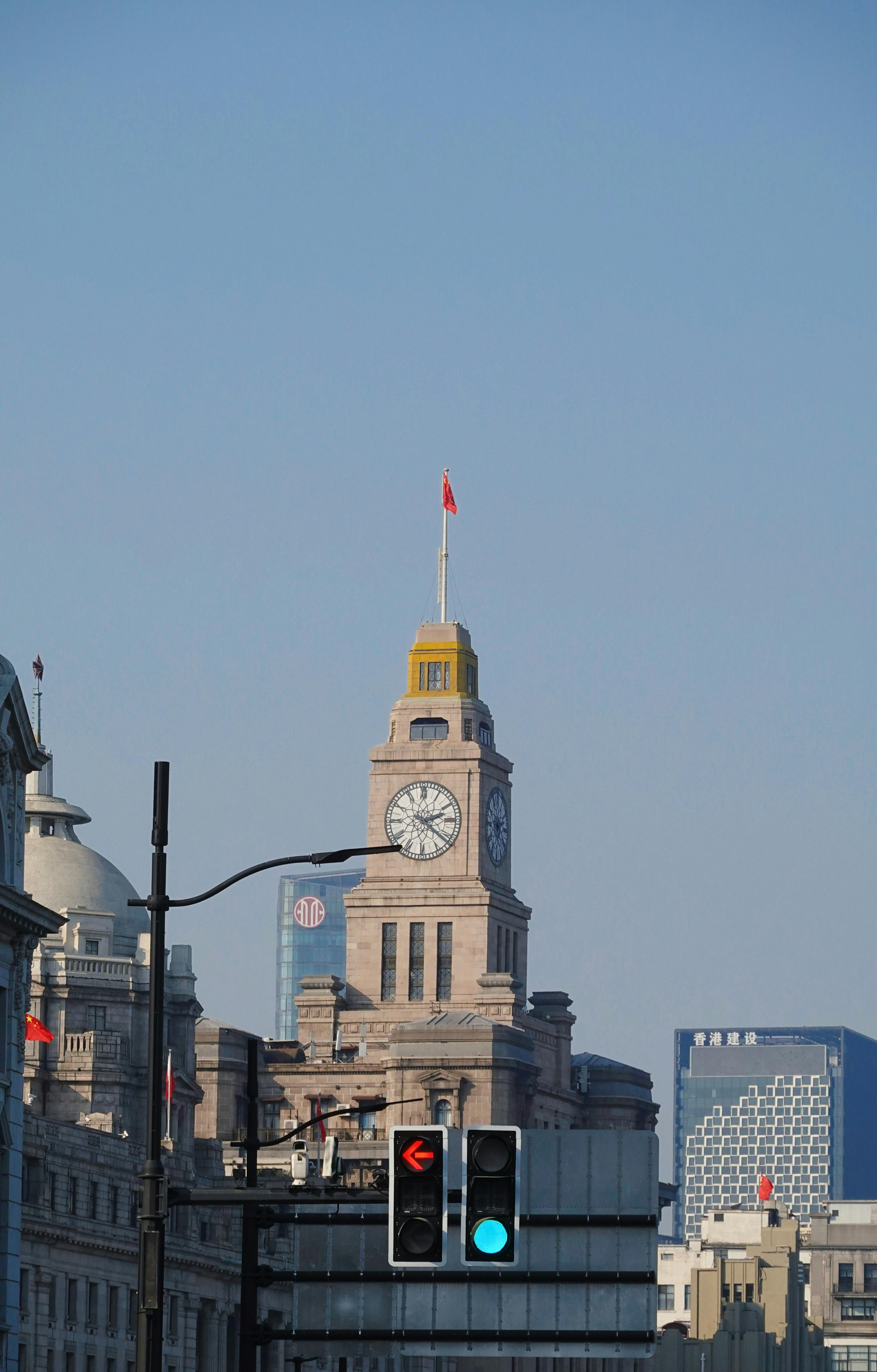 View of the historic clock tower surrounded by modern architecture in Shanghai.