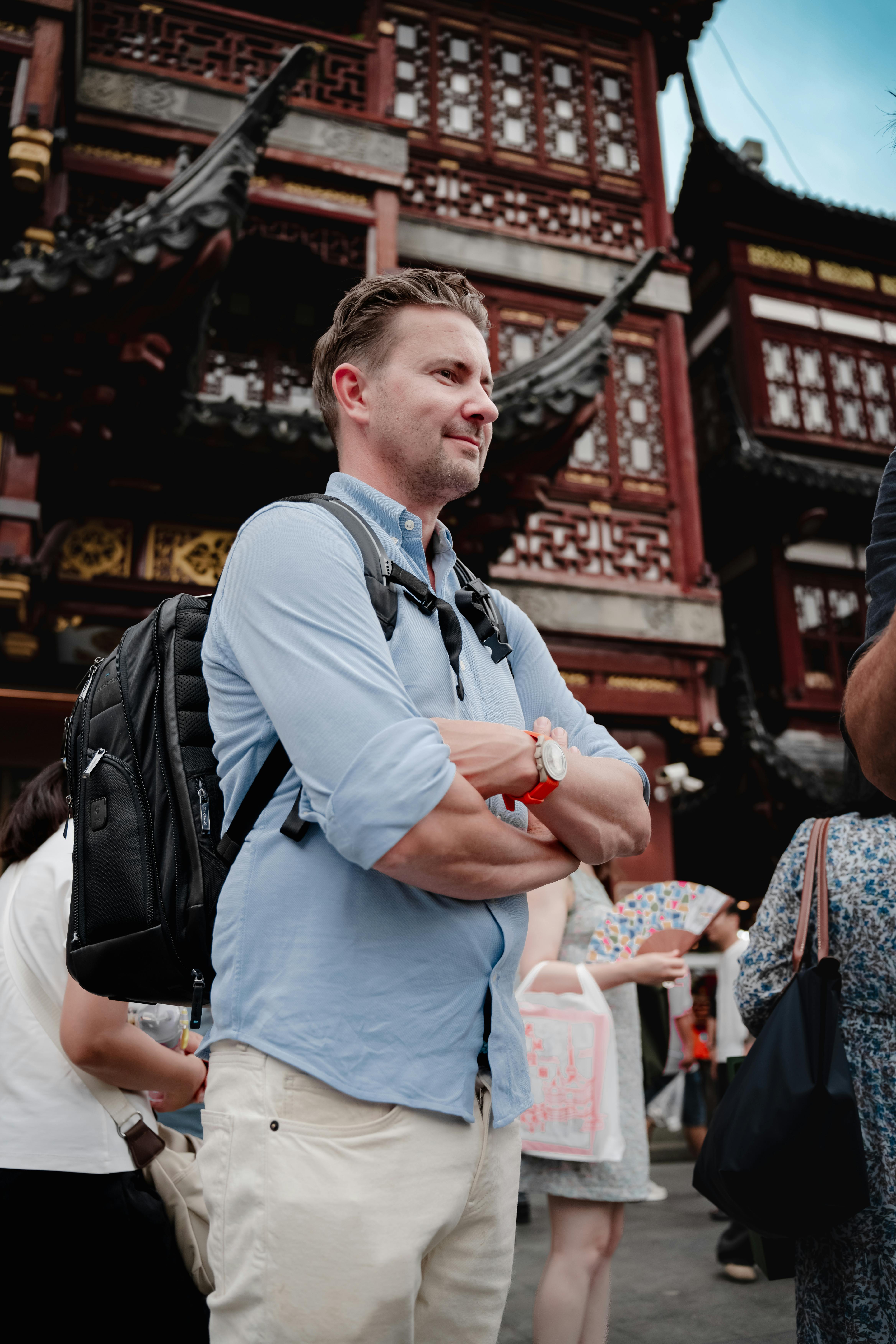 A traveler stands amidst an ornate traditional Asian building, capturing cultural experience.